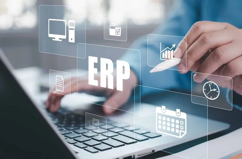 Hands on a laptop keyboard with ERP dashboard icons overlaid